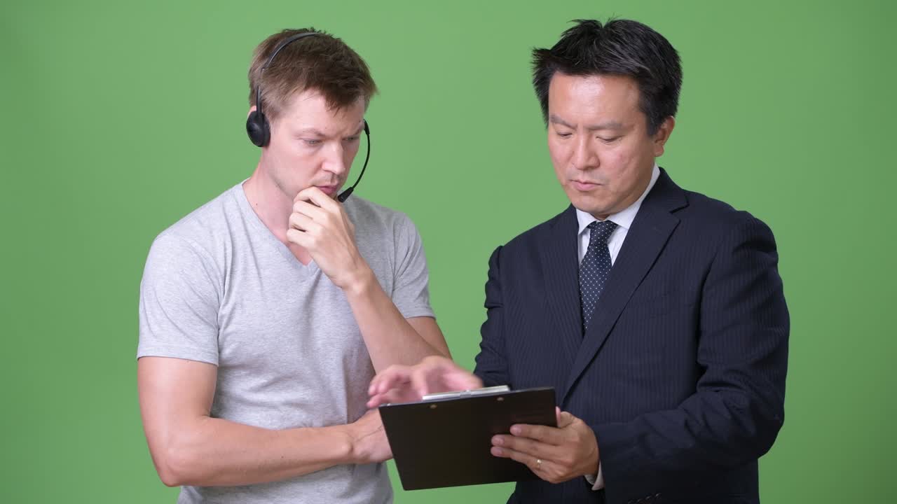 Mature Japanese businessman and young Scandinavian man worker together