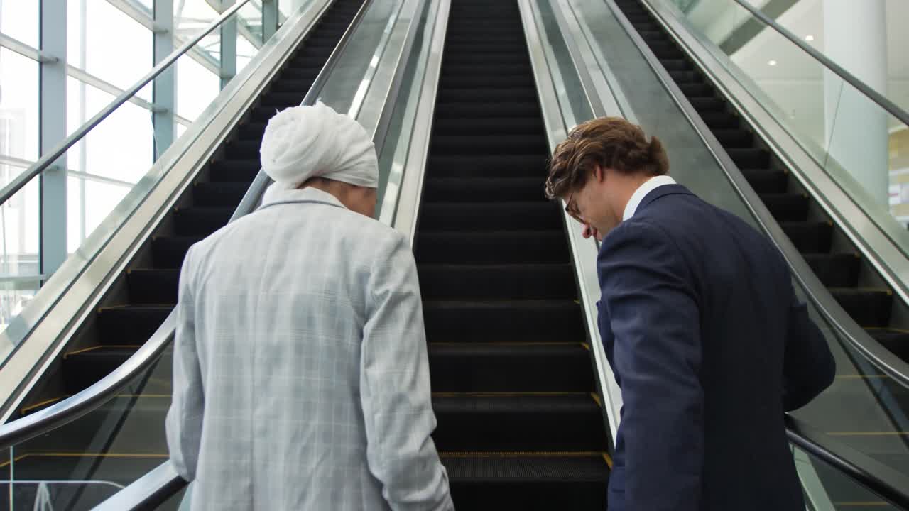 현대 건물 의 에스컬레이터 에 있는 젊은 사업가 들