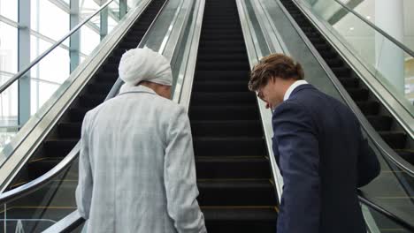 jóvenes de negocios en una escalera mecánica en un edificio moderno