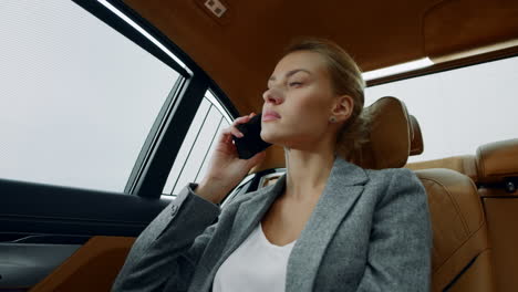 serious business woman having phone call at car. tired girl calling mobile phone