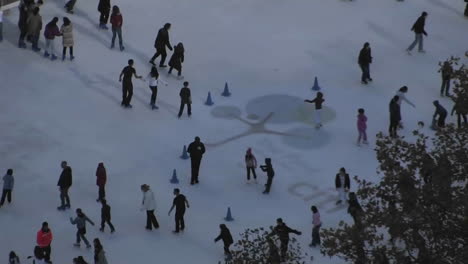 La-Gente-Disfruta-Del-Patinaje-Sobre-Hielo-En-Un-Piso-Nevado