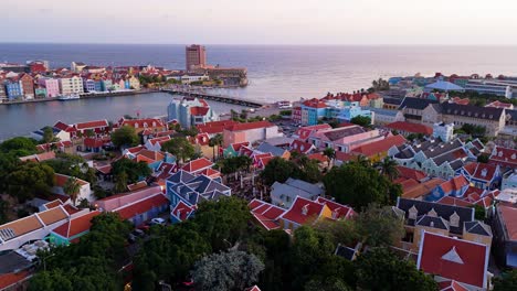 Establishing-orbit-around-Kura-Hulanda-village-in-Otrobanda-Willemstad-Curacao-with-cruise-ship-docked-at-sunset