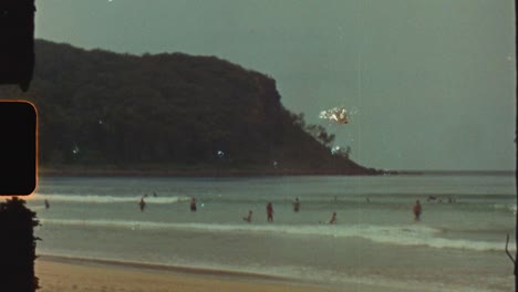 super 8 película vintage de personas nadando disfrutando de las olas del océano verano en la playa de durras cabecera costa costa sur de australia fugas de luz turismo de viajes retro
