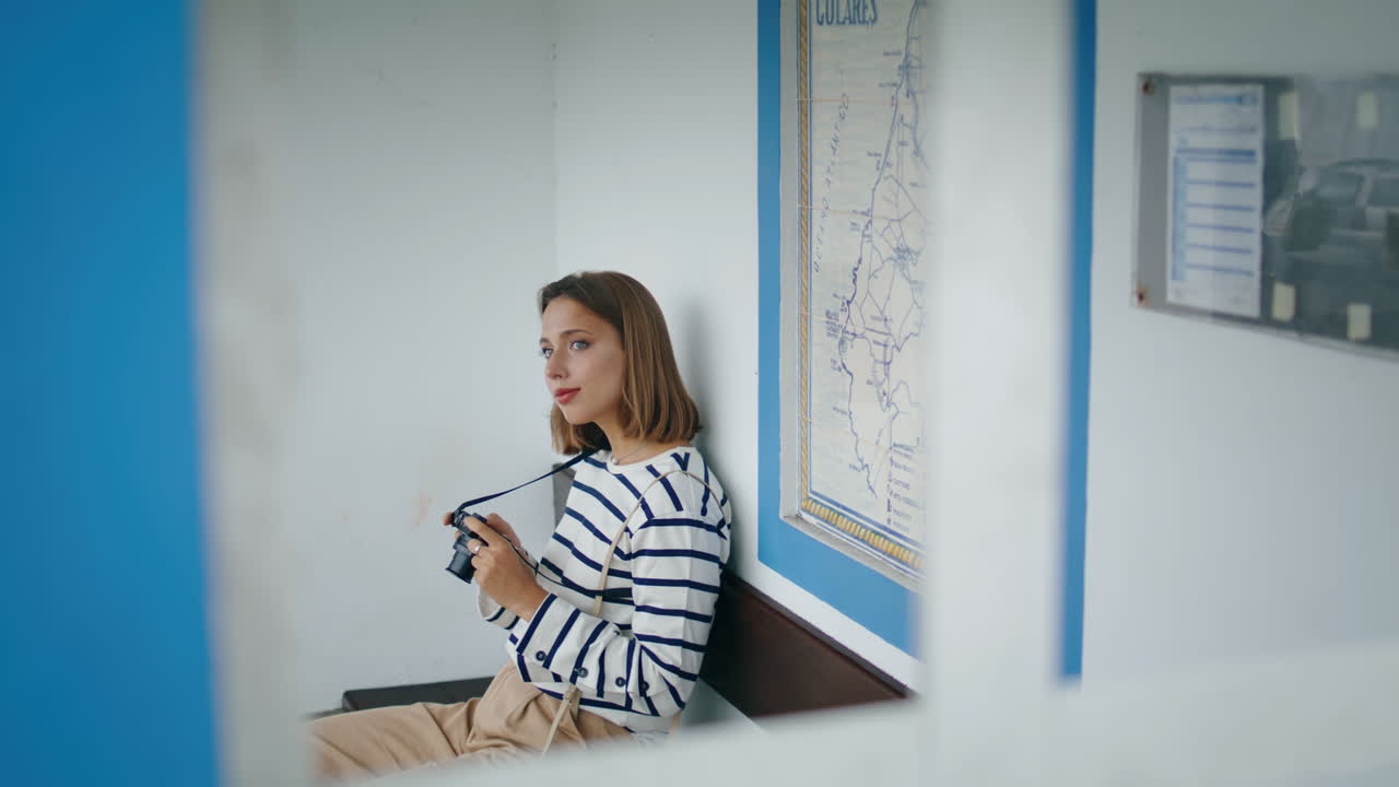 Passeggero che attende il trasporto pubblico durante un viaggio estivo, scatto verticale. Bella ragazza in viaggio.