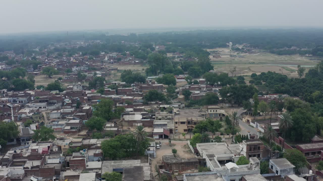 Vista aerea con drone del villaggio di Rahimabad con case in mattoni fitte, alberi e paesaggio rurale nebbioso nell'Uttar Pradesh, India