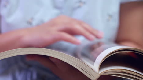 detail of female hands leafing through picture book