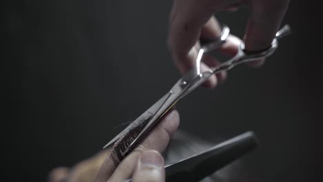 closeup of hairdresser cutting hair to length with scissors