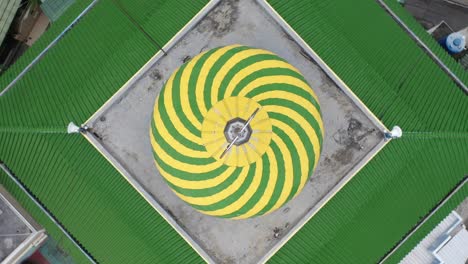 aerial view of a mosque dome with green and yellow spiral design