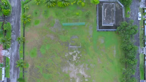 aerial birdseye flying backwards over soccer field, friends playing