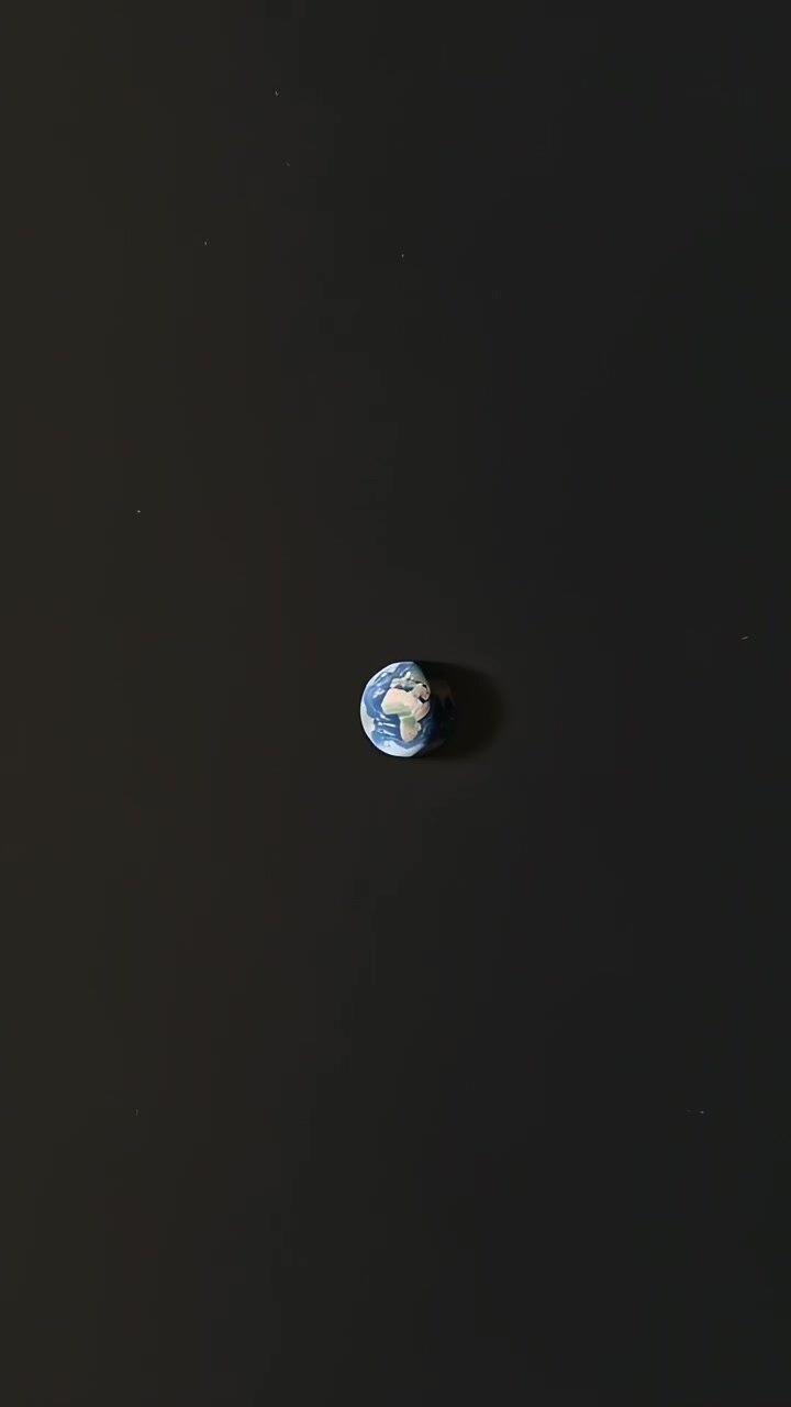 Vertical video: Pulling back revealing globe shrinking in space, Africa visible, showing scale