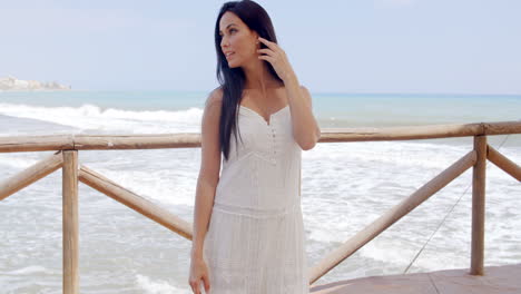 gorgeous lady in white standing at beach pathway