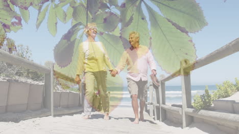 green leaves on tree against caucasian senior couple holding hands walking on the bridge