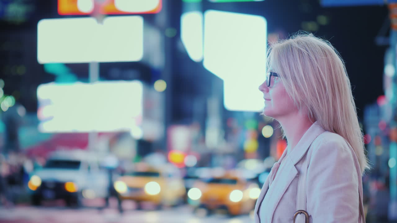 뉴욕 노란 택시가 지나가는 유명한 타임 스퀘어의 불빛을 감상하는 매력적인 여성 -