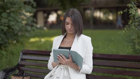 beautiful girl working remotely from a park bench