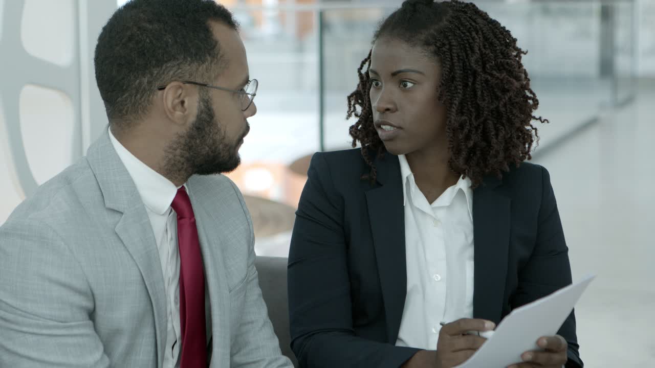 African American coworkers discussing papers