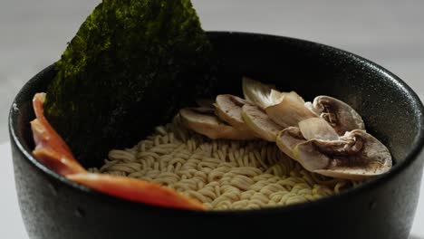 bowl of instant ramen with mushrooms and seaweed