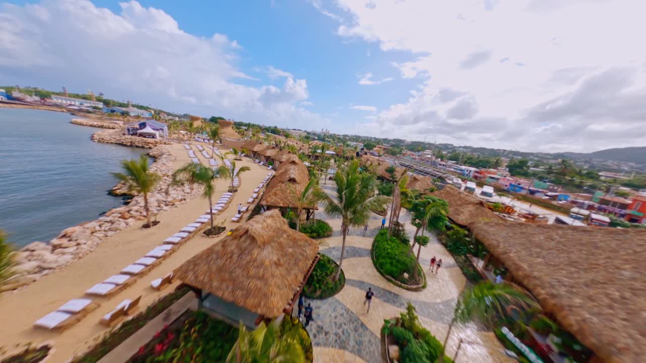 vuelo fpv a lo largo de la costa de taino bay en puerto plata con zona hotelera, piscina y playa privada en verano
