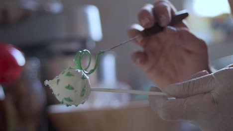 Frau-Dekoriert-Cake-Pops-Mit-Grüner-Geschmolzener-Schokolade