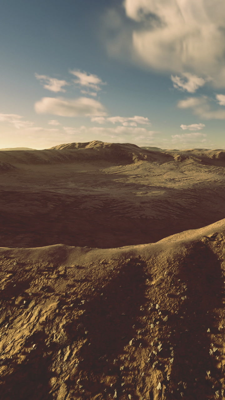 Wide view of a desert landscape showing hills and clouds at sunset