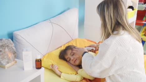 la madre devota toma la fiebre de la niña enferma. el afecto de la madre.