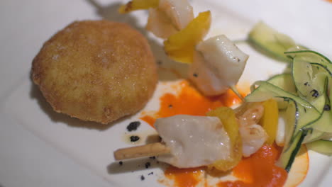 comiendo un plato de restaurante con pinzas de mariscos y croquetas de carne