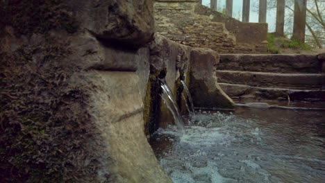 the water falls in to a holy well in the english countryside