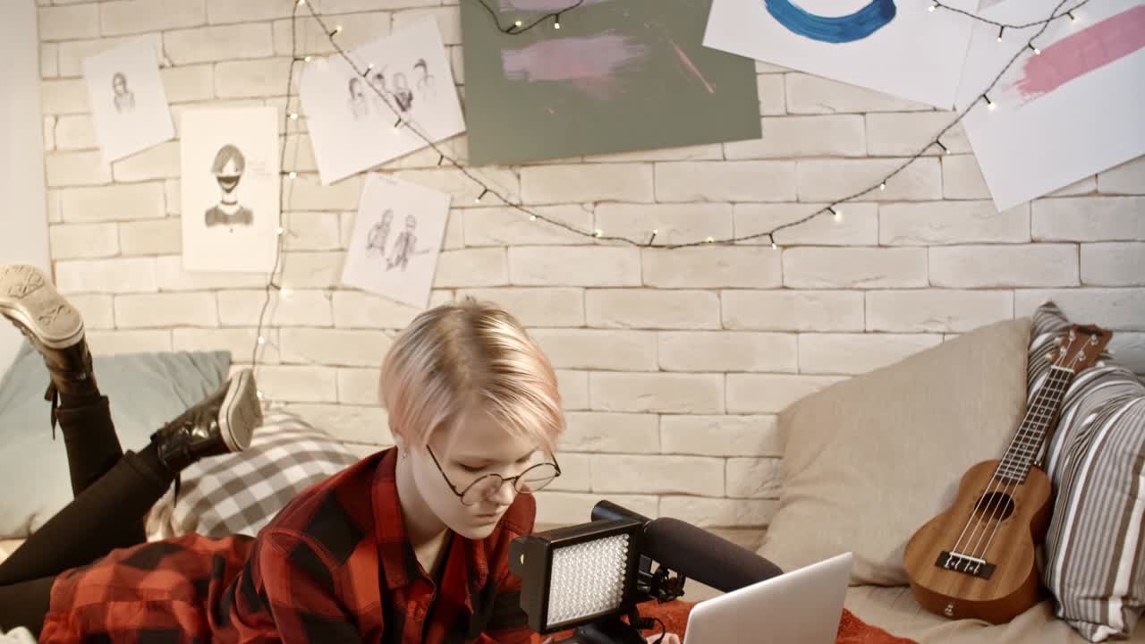 una adolescente con una computadora portátil y una cámara de video