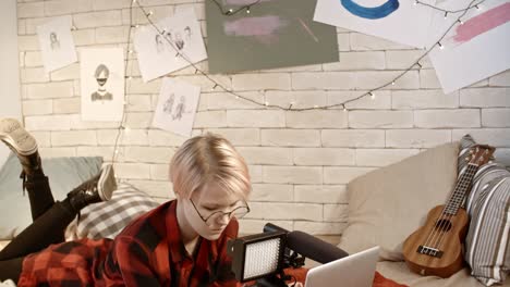 una adolescente con una computadora portátil y una cámara de video