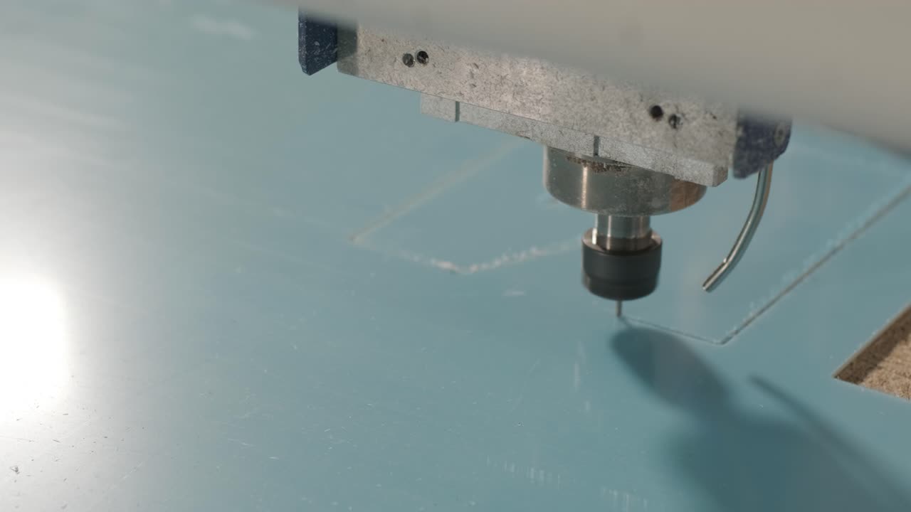 máquina de corte cnc en el trabajo, corte de hojas de plástico acrílico. producción de carteles publicitarios