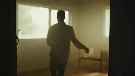 person standing in a doorway, looking into a room