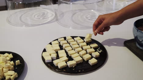 tasting cheese dish on a table. cheese with wine tasting, hand taking a taste of cheese