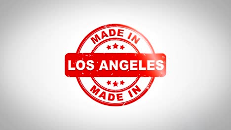 made in los angeles signed stamping text wooden stamp animation. red ink on clean white paper surface background with green matte background included.