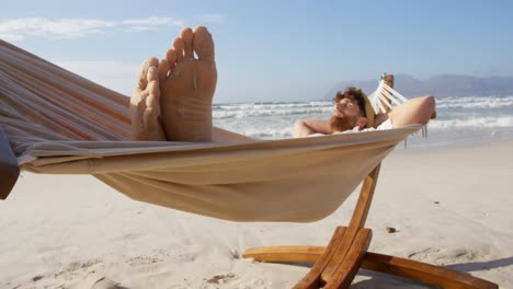 man sleeping in hammock at beach 4k