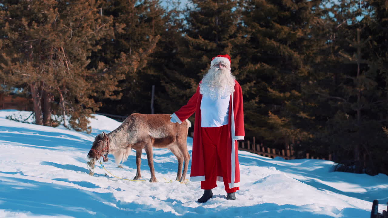 santa claus parado en un camino cubierto de nieve hablando