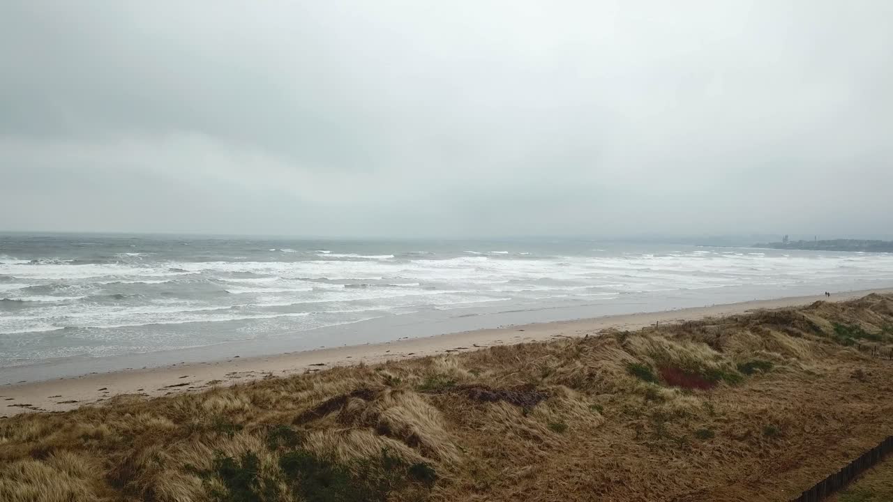 스코틀랜드 세인트 앤드류스 시 근처 해변을 따라 걷는 사람들