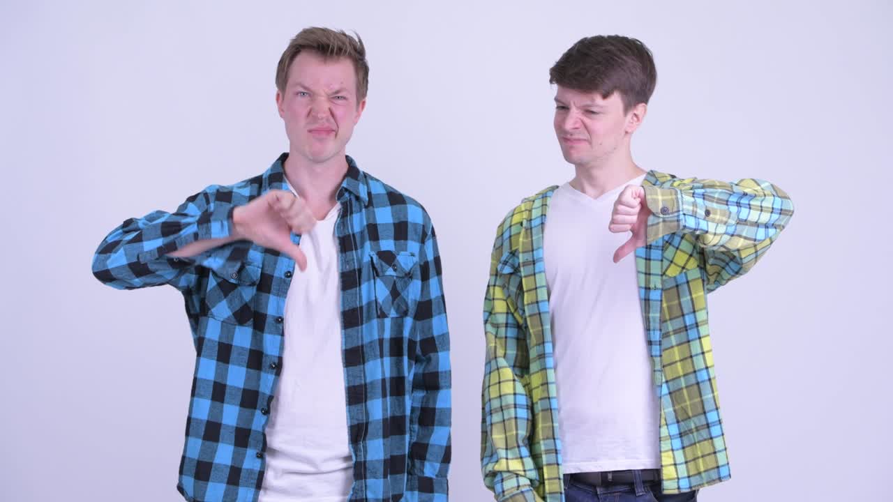 dos jóvenes estresados dando pulgares hacia abajo juntos