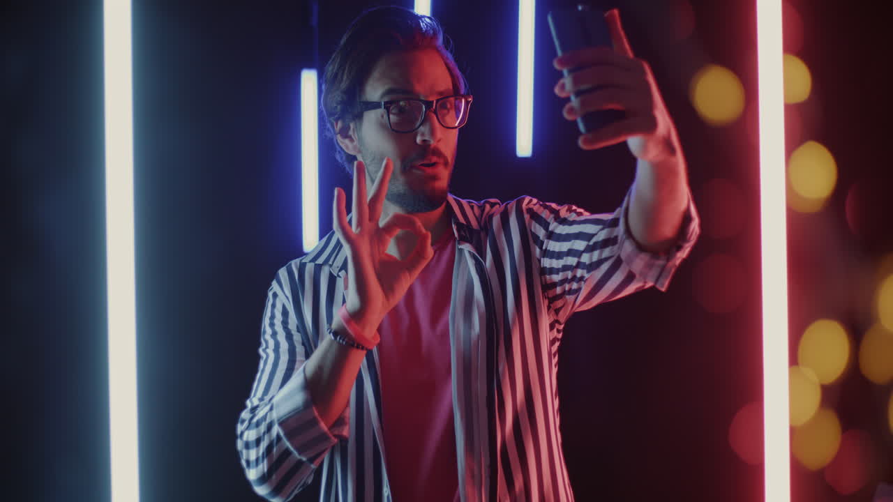 Man Taking a Selfie in Neon Lights