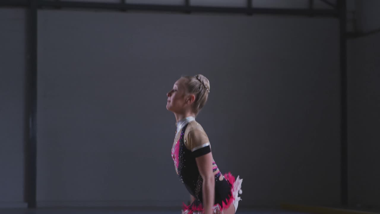 подростковая гимнастка выступает в спортивном зале