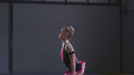 teenage female gymnast performing at sports hall