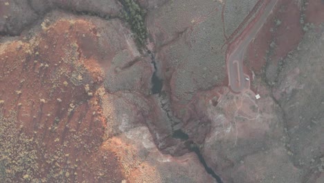 órbita aérea disparó sobre un gran cañón en el parque nacional karijini con un gran desfiladero y un arroyo en el oeste de australia
