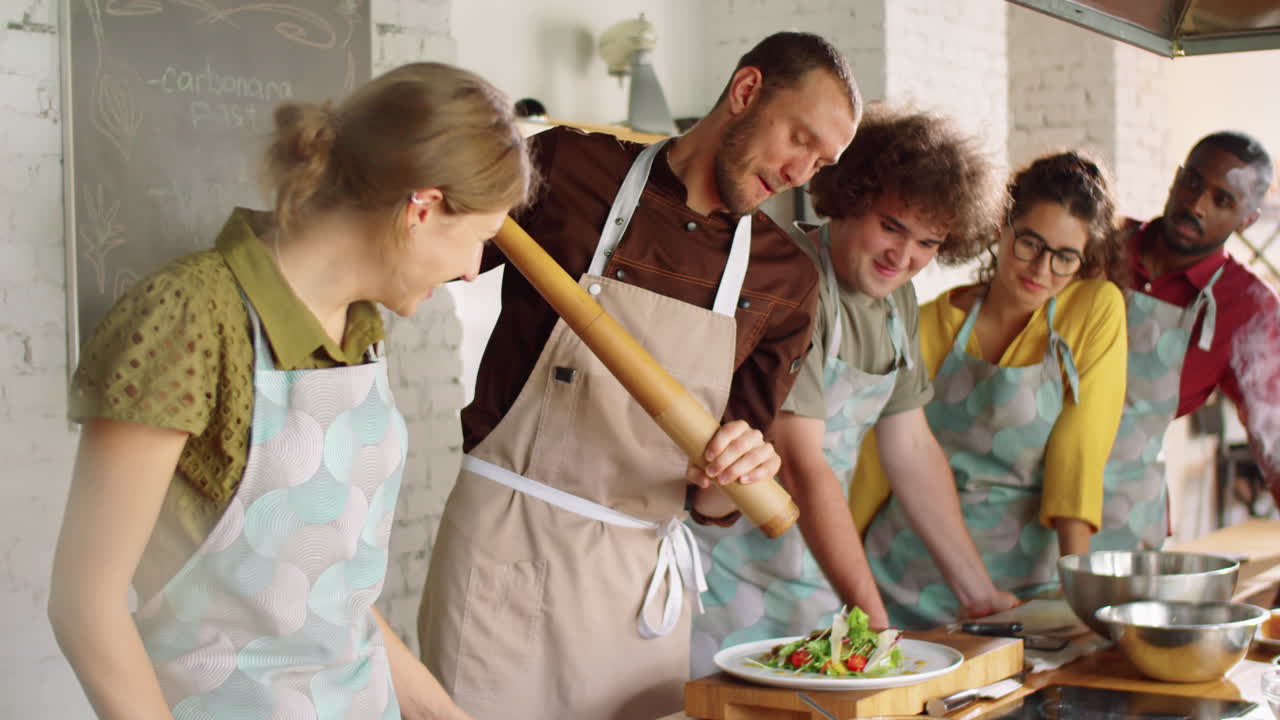chef usando el molino de pimienta gigante durante la clase maestra de cocina
