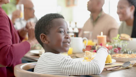 Porträt-Eines-Afroamerikanischen-Sohnes-Mit-Familie-Am-Thanksgiving-Esstisch,-Zeitlupe