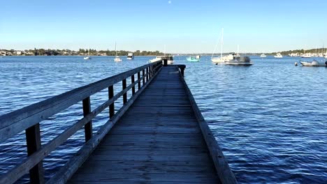 looking down long jetty to boats on swan river at peppermint grove, perth, western australia