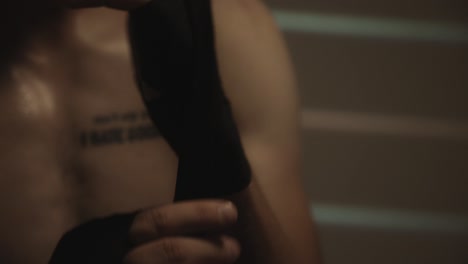 boxer putting on hand wraps before training - close up