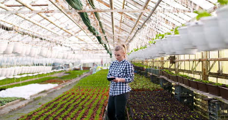 female botanist using calculator at greenhouse 1