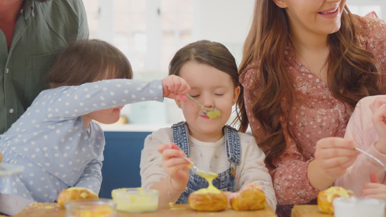 familia con síndrome de down hija horneando y decorando pasteles sentada alrededor de la mesa en casa