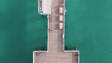 Vista-Aérea-Del-Muelle-Del-Sur-De-California-Con-Una-Hermosa-Puesta-De-Sol-Naranja