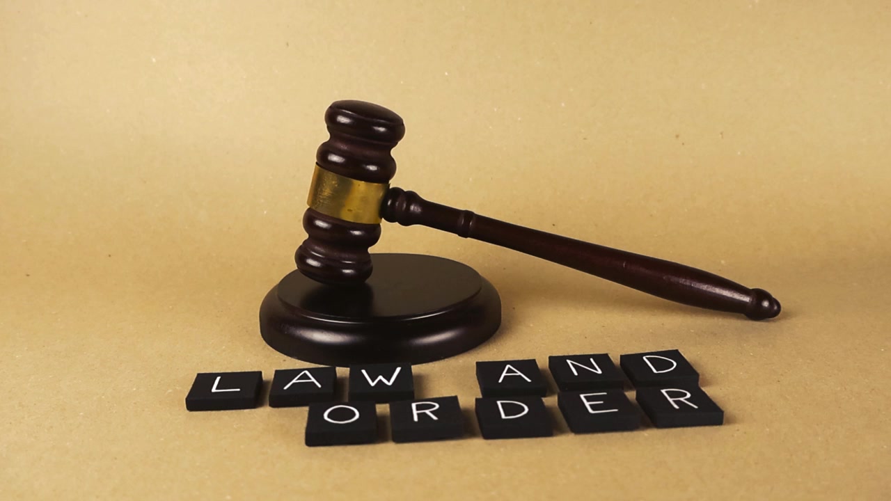 Legal concept footage showing a wooden gavel next to letter tiles spelling law and order. A perfect representation of the justice system, court proceedings, crime, punishment, and legal authority