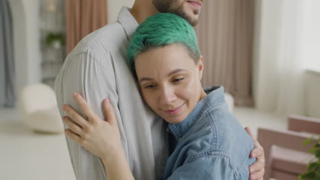 loving young couple hugging and tenderly looking at each other at home