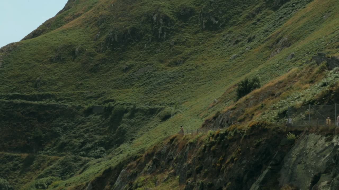 Escursionisti su una collina verde e soleggiata